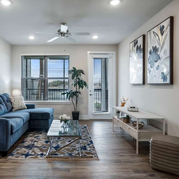 A living room with a blue couch and a rug.