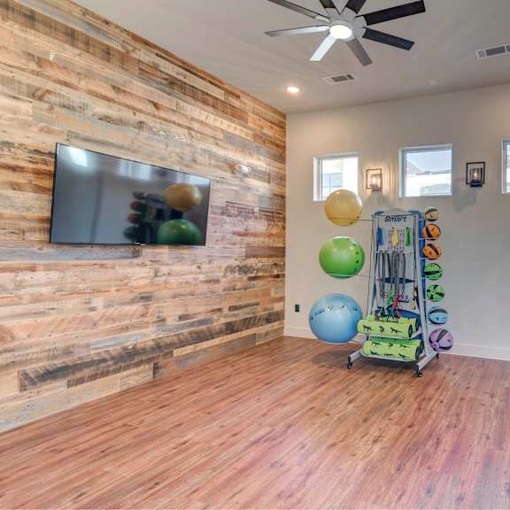 A room with wooden floors and a wooden wall with a TV on it.