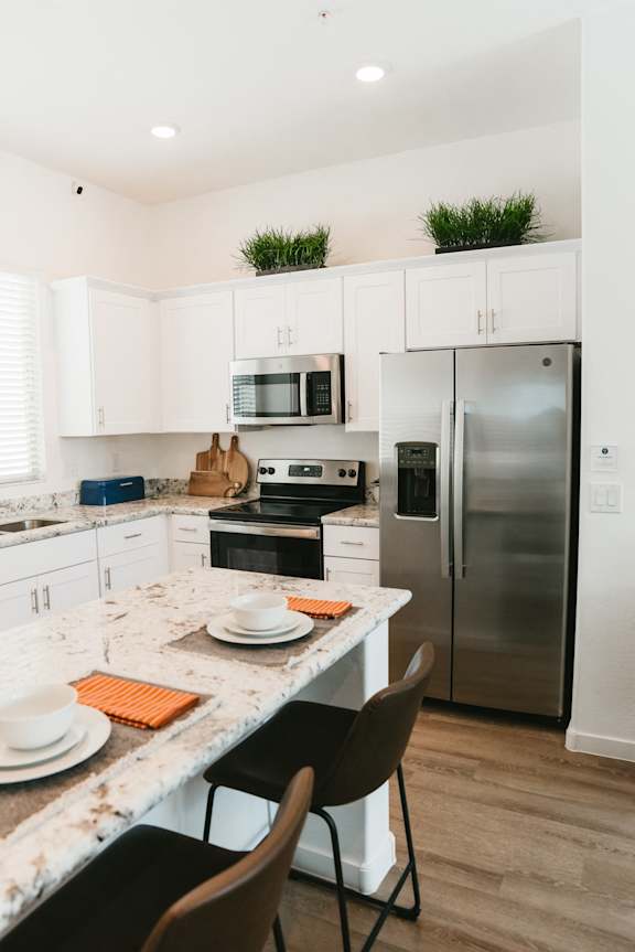 a kitchen with stainless steel appliances and a marble counter top