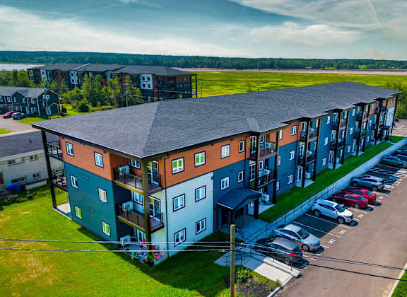 an aerial view of an apartment building with a parking lot