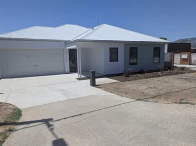 A white house with a grey roof and a grey garage door.