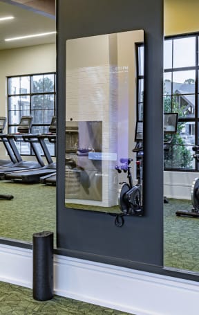 a glass wall with a reflection of a gym mirror in a gym with exercise equipment