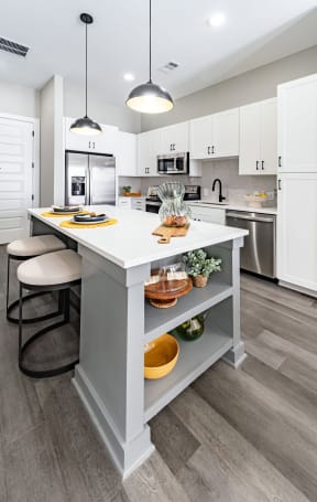 an open kitchen with a large island with two stools