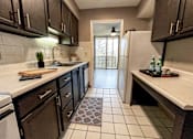 Thumbnail 4 of 28 - A kitchen with brown cabinets and a white fridge.