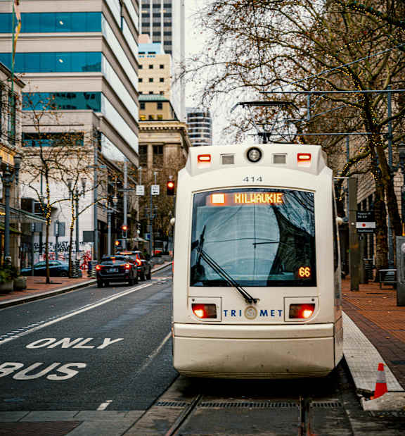A white tram with the number 414 is on a street.