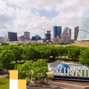 a cityscape with a winnipeg sign in the foreground and the city skyline in the