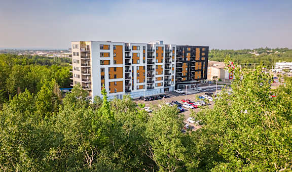 an aerial view of an apartment building surrounded by trees