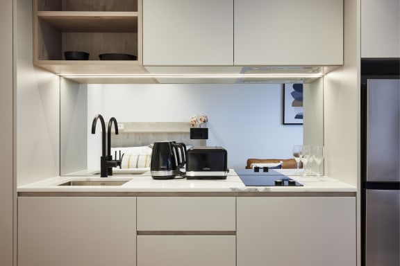 a kitchen with white cabinets and a sink and a window