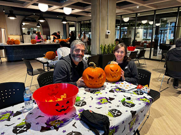 A man and a woman are sitting at a table with Halloween decorations.