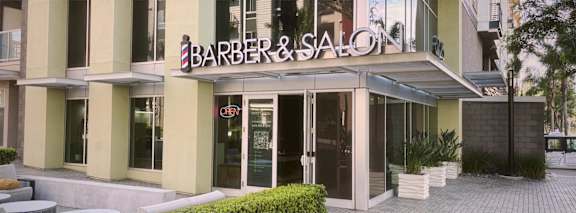 the front of a barber salon building with a sign on the front door
