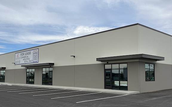 the exterior of a building with windows and a parking lot