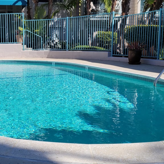 a pool with a fence around it and a chair next to it