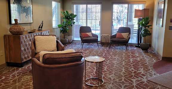 a living room with chairs and a table
