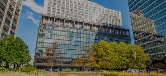 a tall skyscraper with trees in the background and a parking lot in the foreground at The Washington at Chatham, Pittsburgh, PA 15219