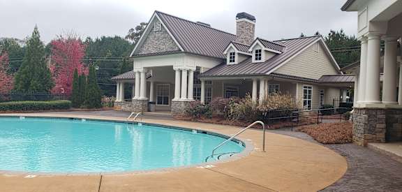 A house with a pool in front of it.