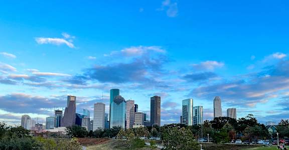 people sitting in a park with the city skyline in the background