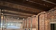 A large, empty warehouse with brick walls and a wooden ceiling.