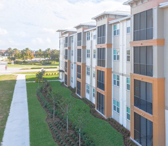 a row of apartment buildings with green grass in front of them