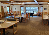 Thumbnail 6 of 6 - A room with tables and chairs and a television.