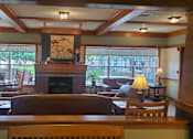 Thumbnail 5 of 6 - A living room with a fireplace and a painting above it.
