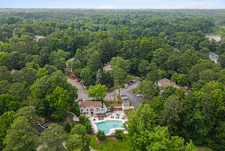 A bird's eye view of a residential area surrounded by a dense forest.