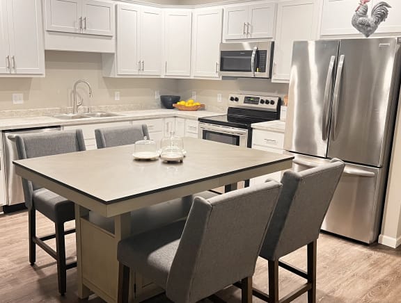 a kitchen with stainless steel appliances and a table and chairs