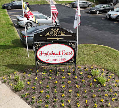 A sign for Holiday Inn Express is in the foreground with a parking lot in the background.