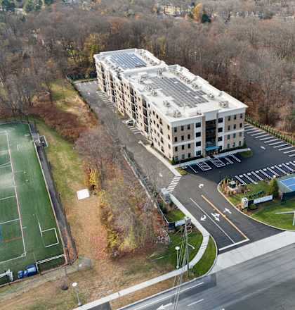 A large building with a tennis court in front of it.