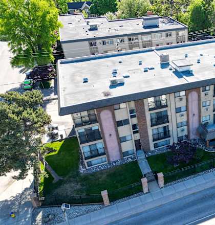 Apartment complex with a parking lot in front.
