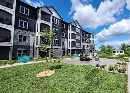 an exterior view of an apartment building with a patio and landscaping