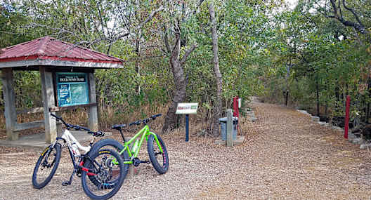 a couple of bikes parked next to a trail sign