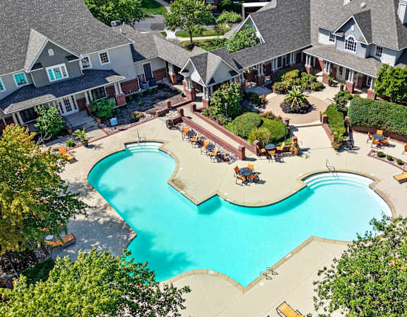 A bird's eye view of a residential area with houses and a swimming pool.