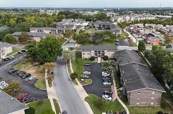 A bird's eye view of a residential area with houses and parked cars.
