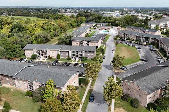 A large apartment complex with a parking lot in front.