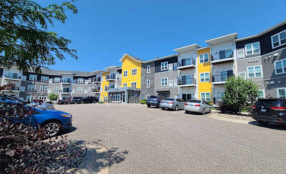 an empty parking lot in front of an apartment building