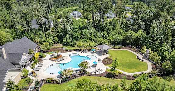 A large backyard with a swimming pool and a gazebo.