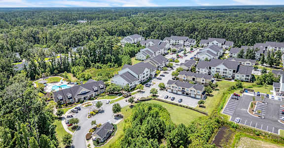 A bird's eye view of a residential area with houses and a parking lot.