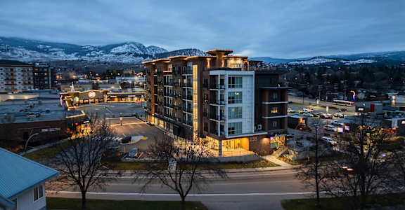 A modern building with a parking lot in front of it.