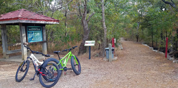 a couple of bikes parked next to a trail sign