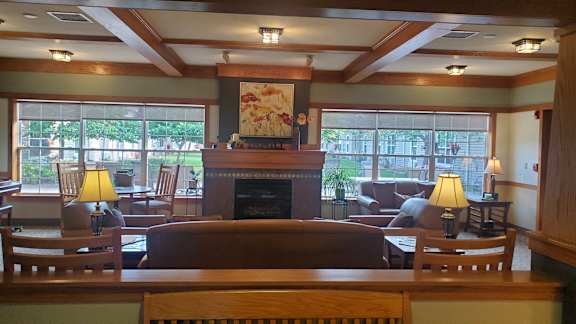 A living room with a fireplace and a painting above it.