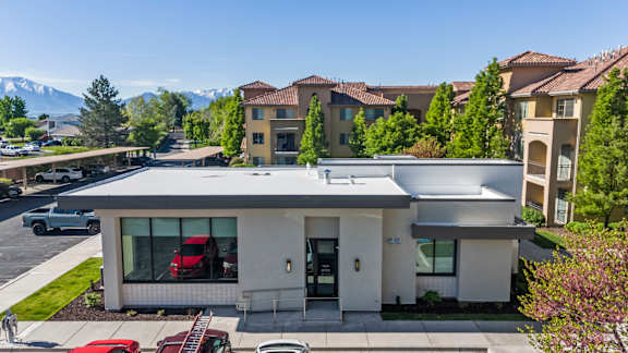 A modern house with a red car parked in front.