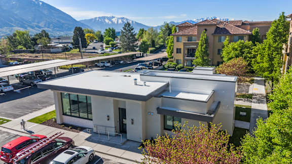 A modern building with a parking lot in front of it.