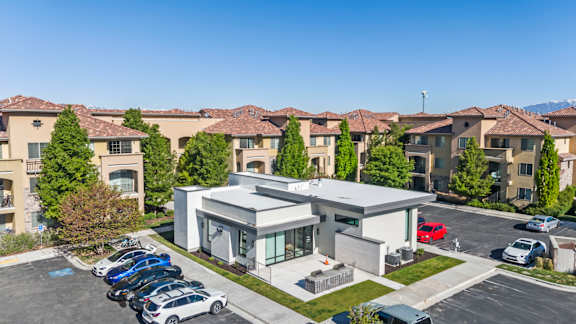 A modern building with a parking lot in front of it.