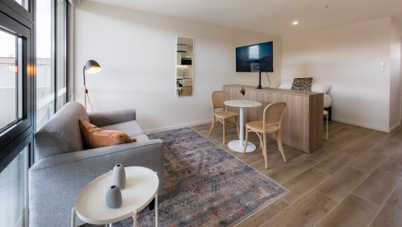 a living room and dining area with a couch and a tv