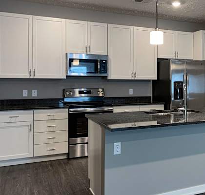 a kitchen with a large counter island and stainless steel applances