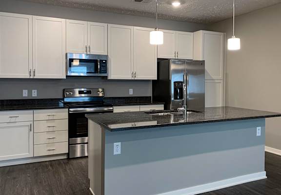 a kitchen with a large counter island and stainless steel applances
