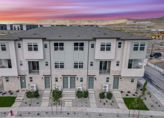 an aerial view of an apartment building with a sunset in the background