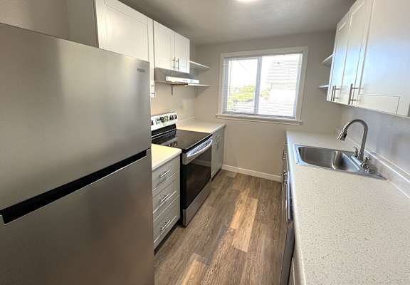 A kitchen with a stainless steel refrigerator and a sink.