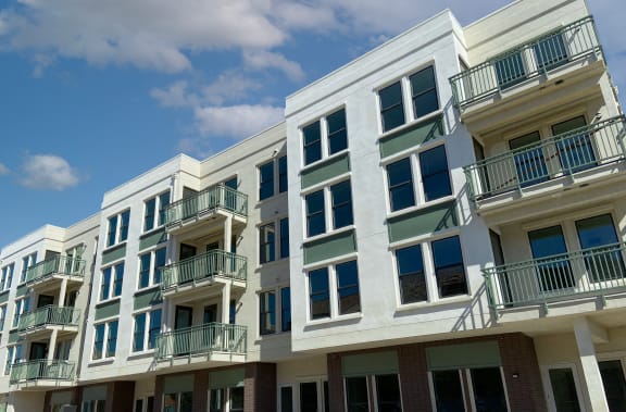 a row of apartment buildings with balconies and a blue sky