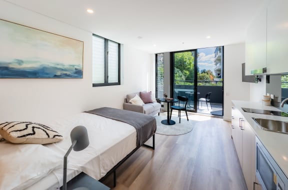 a bedroom with a bed and a kitchen and a patio